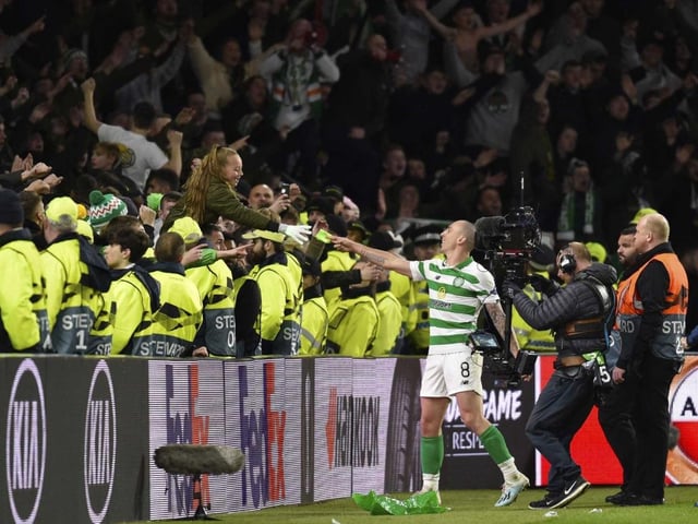 Celtic captain Scott Brown gives his captain's armband to a young fan after the match